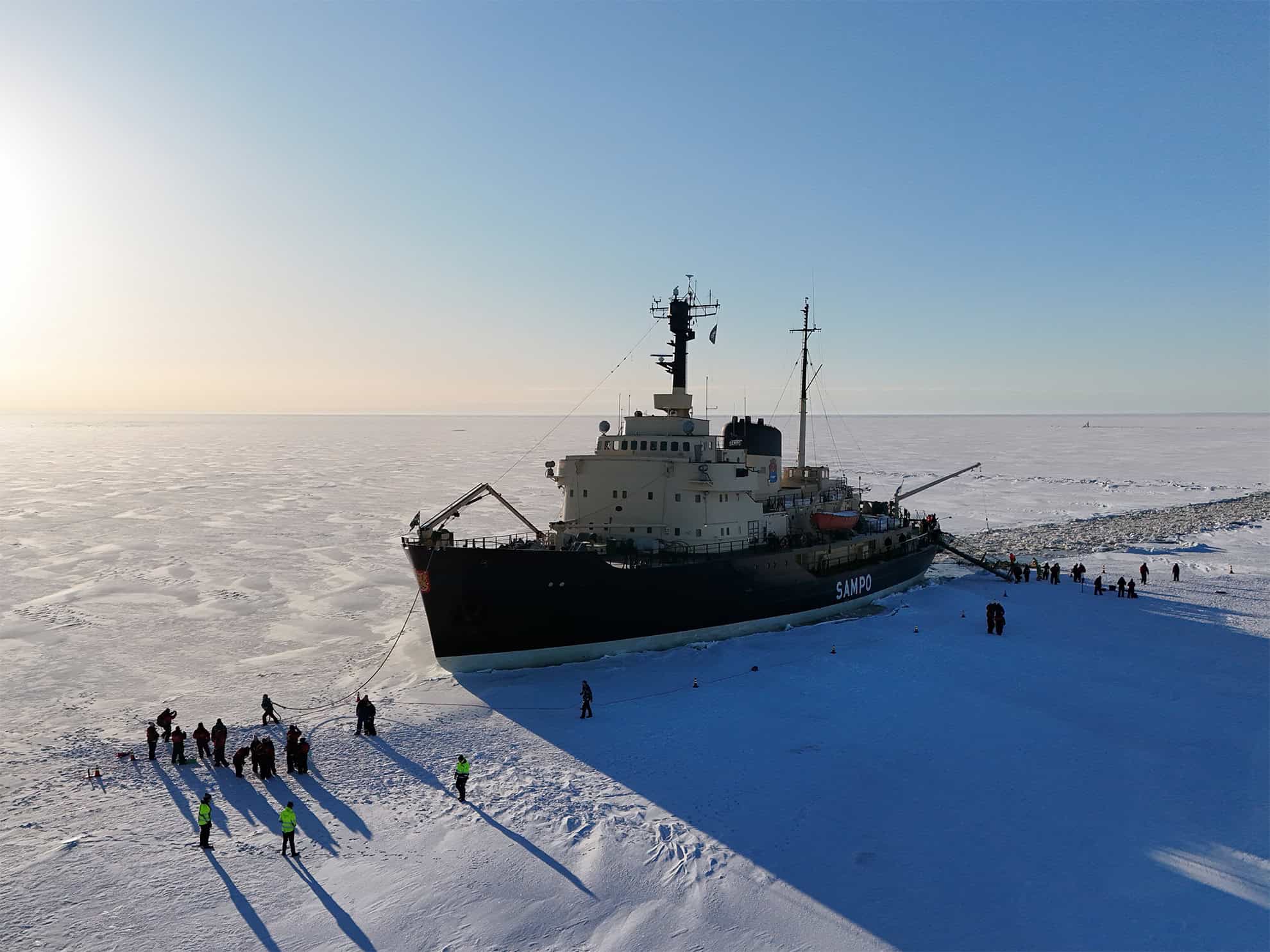 Large icebreaker ship navigating icy waters in Arctic region.